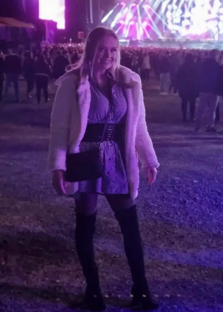Girl wearing a fur coat on top of her outfit at a country concert