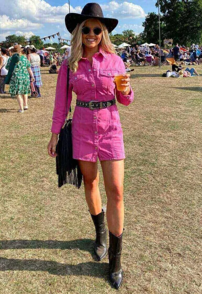 Girl wearing a pink romper and a brown hat at a country concert