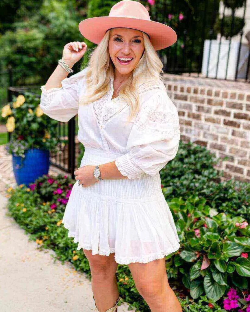 Girl wearing a white cotton mini dress and pink hat