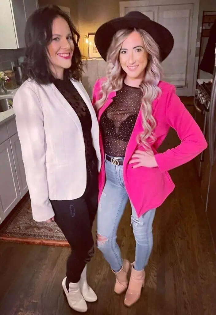 Girl wearing a pink blazer over a black see through top and a black hat